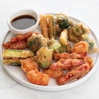 一张小照片，蔬菜天妇罗在一个盘子和一个小碗酱油