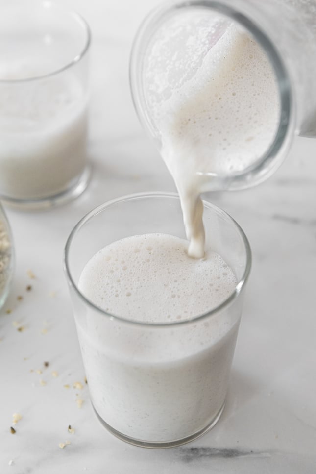Photo of a bottle pouring hemp milk into a glass