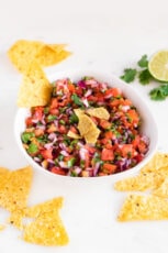 Photo of a bowl of homemade pico de gallo with some tortilla chips
