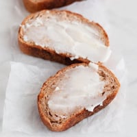 一些素食黄油涂在面包片上的正方形照片